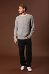 Sweater gris de punto trenzado con cuello redondo y mangas largas.