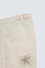 Bermuda regular fit color beige con bordados de flores en tono marrón. Tiene cintura elástica ajustable con cordón, bolsillos laterales y un bolsillo trasero de plastrón.