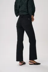 Pantalón de jean negro de tiro alto, corte flare y pretina con trabillas. Confeccionado en denim 100% algodón.