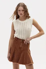 Minifalda acampanada de denim color caramelo con cintura alta y ruedo desflecado.