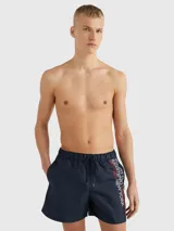 Short de baño azul marino con cintura elástica ajustable con cordón. Estampado vertical con el logo de Tommy Hilfiger en blanco y rojo en la pierna derecha.