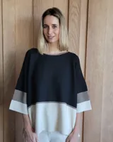 Buzo de punto con mangas 3/4, corte amplio y diseño a bloques de color negro, gris y blanco.