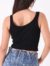 Musculosa corta negra de algodón con breteles anchos y escote cuadrado. Presenta un pequeño bordado de una mariposa azul en el centro del pecho.