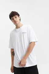 Remera blanca de manga corta con estampado en la espalda con texto en gris y diseño floral.
