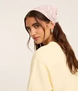 Bandana elástica con estampado de cuadros vichy color lila y flores blancas.