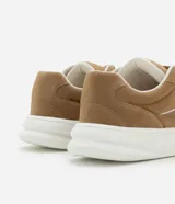 Championes de skate color marrón, confeccionados en material sintético con cordones anchos blancos, suela alta blanca y detalles contrastantes en los laterales.