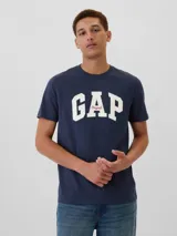 Remera azul marino de algodón, de manga corta y cuello redondo. Estampado frontal con el logo de la marca GAP en color blanco y detalle en rojo.