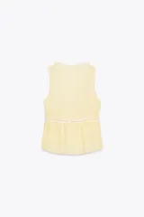 Blusa amarilla sin mangas con escote en pico y detalle de puntillas blancas. Cierre frontal con botones.