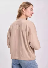 Remera color beige de corte oversize, confeccionada en algodón. Presenta un estampado del sol de la bandera de Uruguay con la leyenda "República Oriental del Uruguay" y el año "Est. 1825". Tiene bordado el texto "milonga" en la manga.