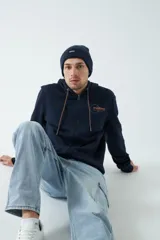 Campera de felpa color ladrillo con capucha ajustable, cierre frontal y bolsillos laterales con cierre. Tiene puños y logo bordado en la espalda.