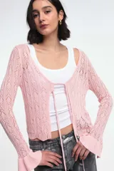 Cárdigan de punto calado color rosa claro, con escote en V y cierre frontal con lazos. Tiene mangas largas acampanadas.