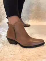 Botín de cuero color borgoña, con punta fina, cierre lateral y taco bajo de madera.