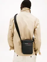 Bandolera Tommy Hilfiger negra con logo de la marca y franja tricolor.