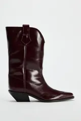 Bota de cuero color bordó, estilo cowboy, con puntera marcada y tiradores laterales.