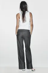 Pantalón de jean azul oscuro, de tiro alto y corte bootcut. Presenta bolsillos delanteros y traseros.