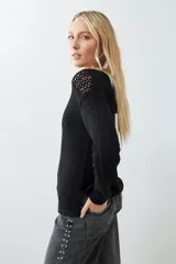 Sweater negro de tejido de punto con calado en la parte superior delantera y en los hombros.