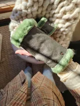 Mitones de cuero color gris con borde de corderito verde.