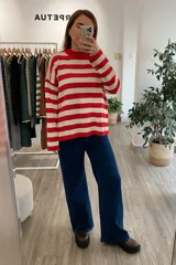 Sweater de punto con rayas rojas y beige, de manga larga y cuello redondo, confeccionado en Uruguay.