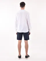 Camisa negra de manga larga con cuello mao y botones blancos frontales.