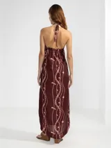 Vestido largo marrón con estampado de cadenas y flores rosadas, escote halter con cordón ajustable y insignia Polonio removible.