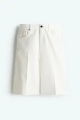 Bermuda blanca de denim rígido de algodón, corte holgado, tiro bajo, cinco bolsillos, raya adelante y atrás, y cierre con botón.