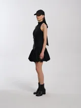 Minifalda negra de nylon con pretina alta, cierre delantero y forro de algodón.