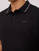 Remera polo negra de corte regular, con cuello y mangas con rayas en contraste blancas y logo bordado en el pecho.