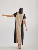 Vestido largo rojo de tejido de punto, con cuello en V y mangas cortas. Presenta costuras verticales a lo largo del vestido.