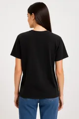 Remera negra de algodón, manga corta, corte holgado y cuello redondo.