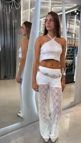 Pantalón de encaje blanco con diseño de flores caladas, de corte wide leg y tiro bajo. No incluye el short interior.
