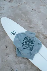 Hoodie gris con estampado en el frente de palmeras y texto en negro.