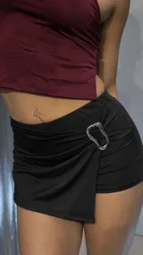 Short pollera negro con detalle de hebilla metálica plateada en el lateral.