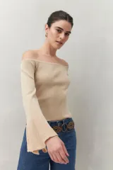 Top tejido color beige con escote off-shoulder y mangas largas acampanadas.