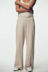 Pantalón de algodón color beige, de tiro medio, pierna ancha y cintura elastizada.