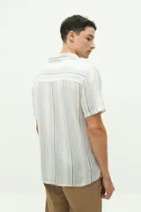 Camisa de manga corta confeccionada en lino y algodón a rayas verticales en tonos blanco, gris y beige. Tiene cuello tipo cubano, corte regular y logo bordado en el pecho.
