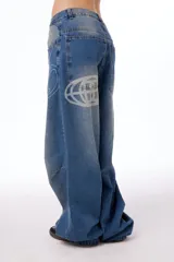 Jean oversized de tiro bajo, color azul lavado, con estampa BLKMBA grabada con láser en el frente y estampa worldwide en la parte trasera.