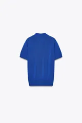 Top azul eléctrico de punto, con cuello polo, manga corta y cierre frontal con botones negros.