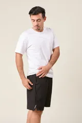 Bermuda deportiva de nylon color verde oliva, de corte suelto, con cintura elástica y cordón de ajuste. Cuenta con detalles de líneas verticales en los costados y bolsillos laterales con cierre.