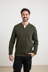 Remera de tejido elastizado en color verde militar, con cuello tipo camisa y botones frontales.