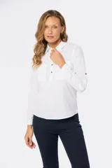 Camisa blanca de lino con mangas largas, cuello clásico, medio abotonada y bolsillo en el pecho. Tiene presilla en la manga para mayor comodidad.