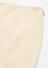 Falda larga color beige de tejido grueso con abertura delantera.