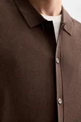 Camisa marrón de punto con viscosa, corte relaxed fit, cuello solapa, manga corta y cierre frontal con botones.
