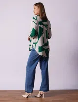 Camisa de manga larga con estampado abstracto en tonos verde y blanco. Cuello con solapa y abertura central con botones. Largo de manga regulable con presilla y botón. Terminación de ruedo anudada opcional.