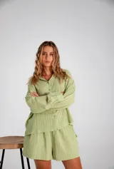 Conjunto verde claro con camisa de manga larga abotonada y short.