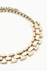 Collar corto dorado con eslabones rectangulares.