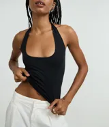 Blusa frente única color beige, con escote cuadrado y bretel ajustado en el cuello. Confeccionada en microfibra, es sin mangas y de corte ajustado.