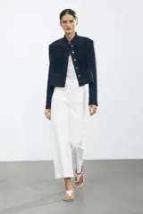 Pantalón de jean celeste de tiro alto y corte wide leg, con bolsillos frontales y traseros, cierre frontal con cremallera y botón metálico.