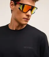 Remera deportiva negra de poliéster y elastano, con tecnología dry, cuello redondo, manga corta, textura y estampa lettering en el pecho.