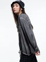 Camisa gris de manga larga confeccionada en viscosa teñida en frío, con efecto gastado. De corte relajado, con bolsillo delantero y puños amplios.