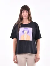Remera color amarillo claro con estampado de limones, hojas y flores en tonos verdes y grises.